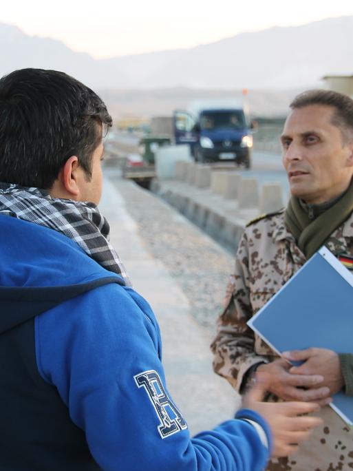 Die afghanische Ortskraft Omid S. (l.) unterhält sich am 11.12.2014 im Camp Marmal in Masar-i-Scharif in Afghanistan mit dem uniformierten Fregattenkapitän Frank Martin.