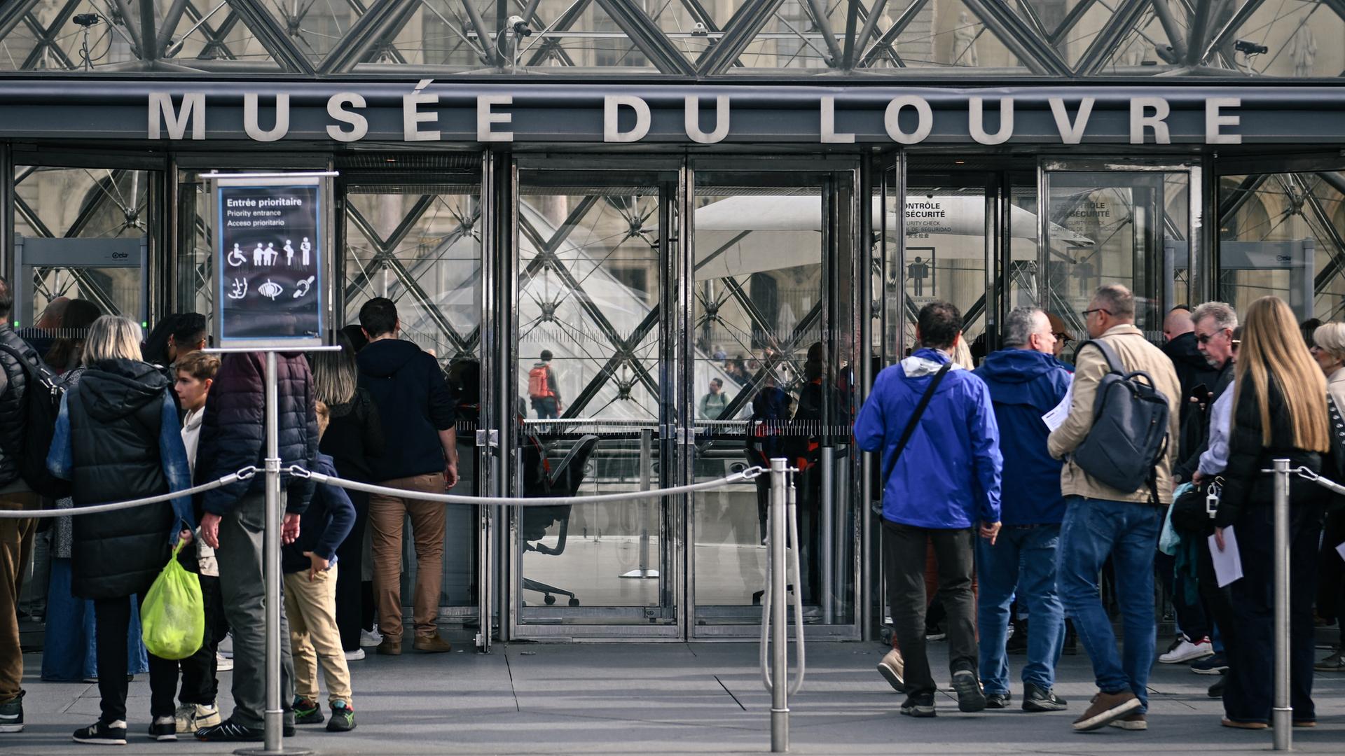 Menschen warten am Eingang des Museums Louvre in Paris. Menschen warten am Eingang des Museums Louvre in Paris.