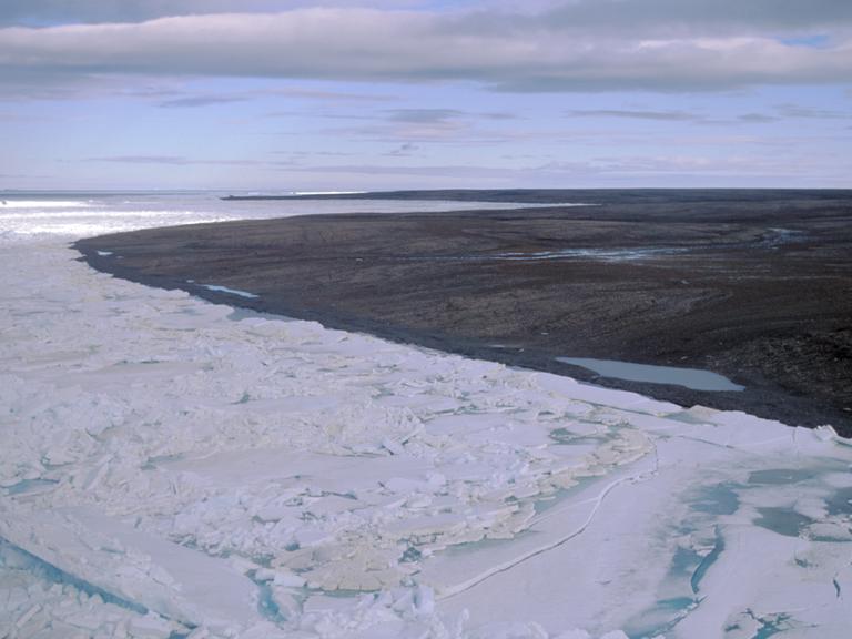 Blick über eine durch Dauerfrost (Permafrost) gezeichnete Landschaft auf der zur Russland gehörenden Bolschewik Insel. Während im Vordergrund noch Packeis herrscht, ist die Landschaft im Hintergrund schon aufgetaut und schlammig. Aufnahme: 24.08.1999