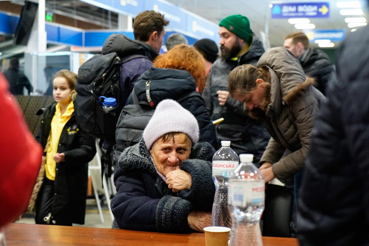 Das Bild zeigt eine ältere Frau, die an einem Tisch sitzt. Sie war aus der ukrainischen Stadt Mariupol geflohen. 

