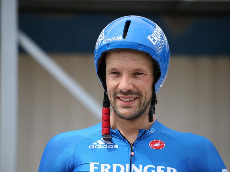 Patrick Lange lächelt mit Helm und Trikot