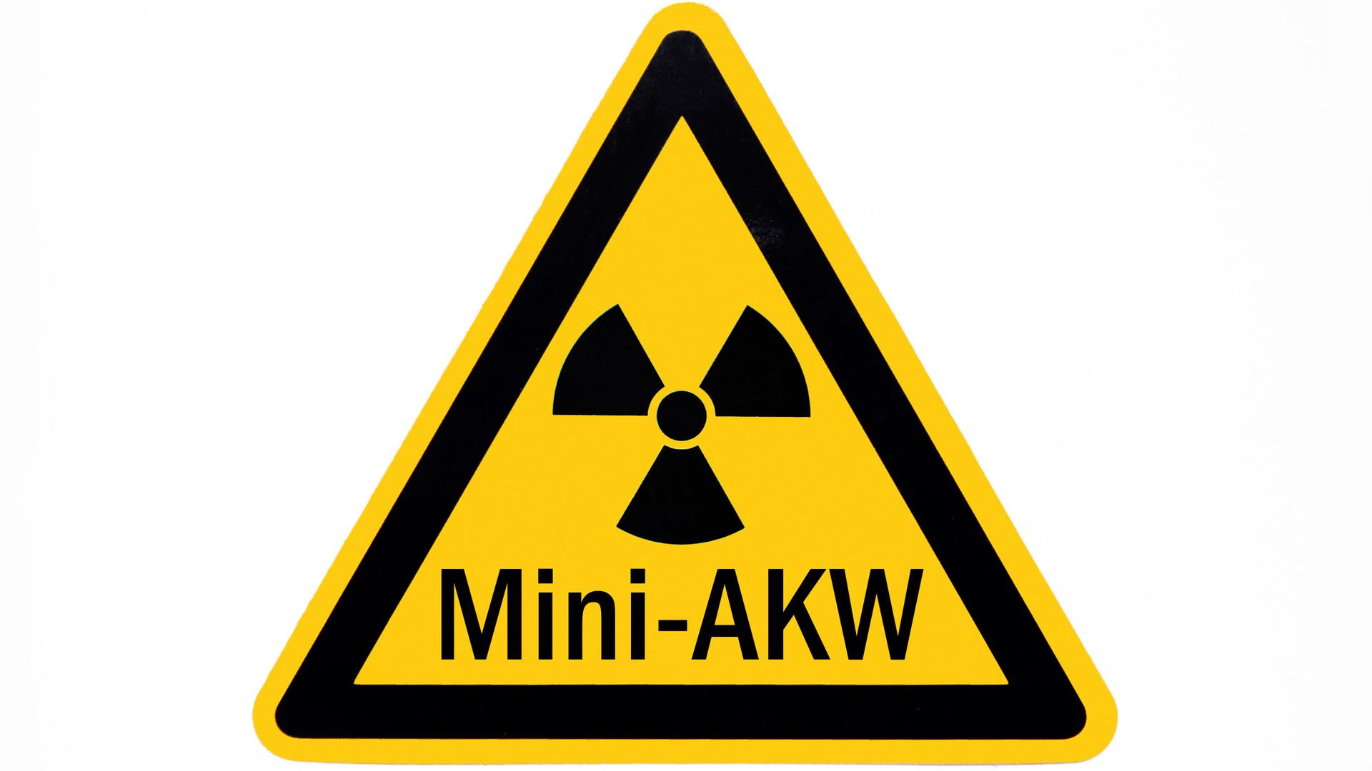 Auf einem Zeichen für Radioaktivität befindet sich der Schriftzug Mini-AKW.