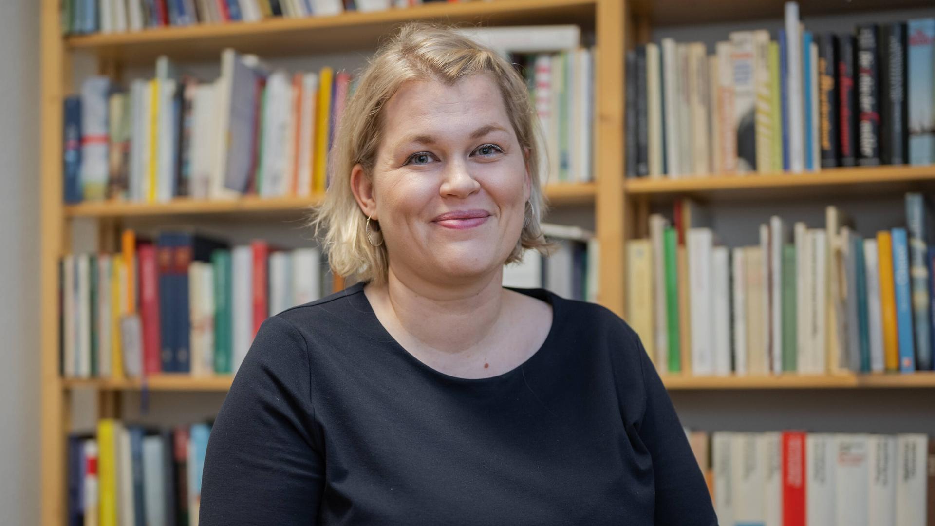Die Schriftstellerin Berit Glanz sitzt im Literaturhaus Schleswig-Holstein in Kiel vor einem Bücherregal und lächelt in die Kamera. Die Schriftstellerin Berit Glanz sitzt im Literaturhaus Schleswig-Holstein in Kiel vor einem Bücherregal und lächelt in die Kamera.