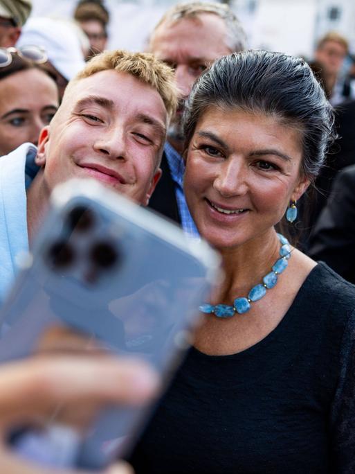 Ein junger Mensch macht ein Selfie mit Sahra Wagenknecht.