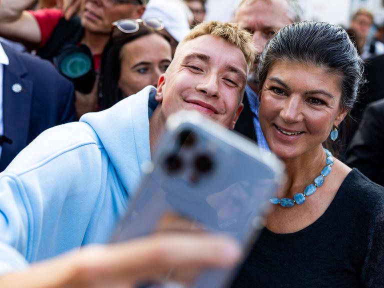 Ein junger Mensch macht ein Selfie mit Sahra Wagenknecht.