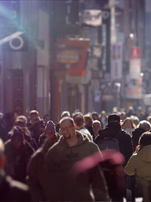 Blick in eine mit Menschen überfüllte Fussgängerzone, die Stimmung ist düster