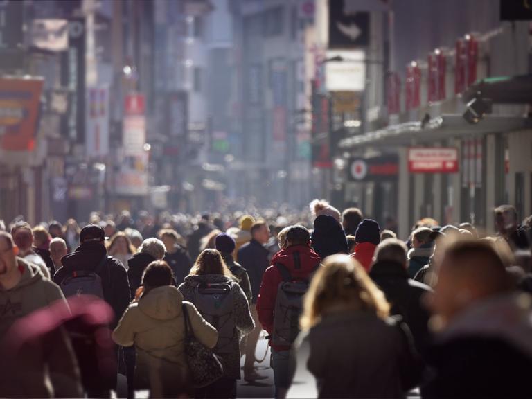 Blick in eine mit Menschen überfüllte Fussgängerzone, die Stimmung ist düster