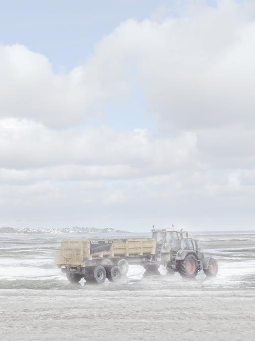 Ein Traktor am Meer, der verschwommen und teils doppelt zu sehen ist.