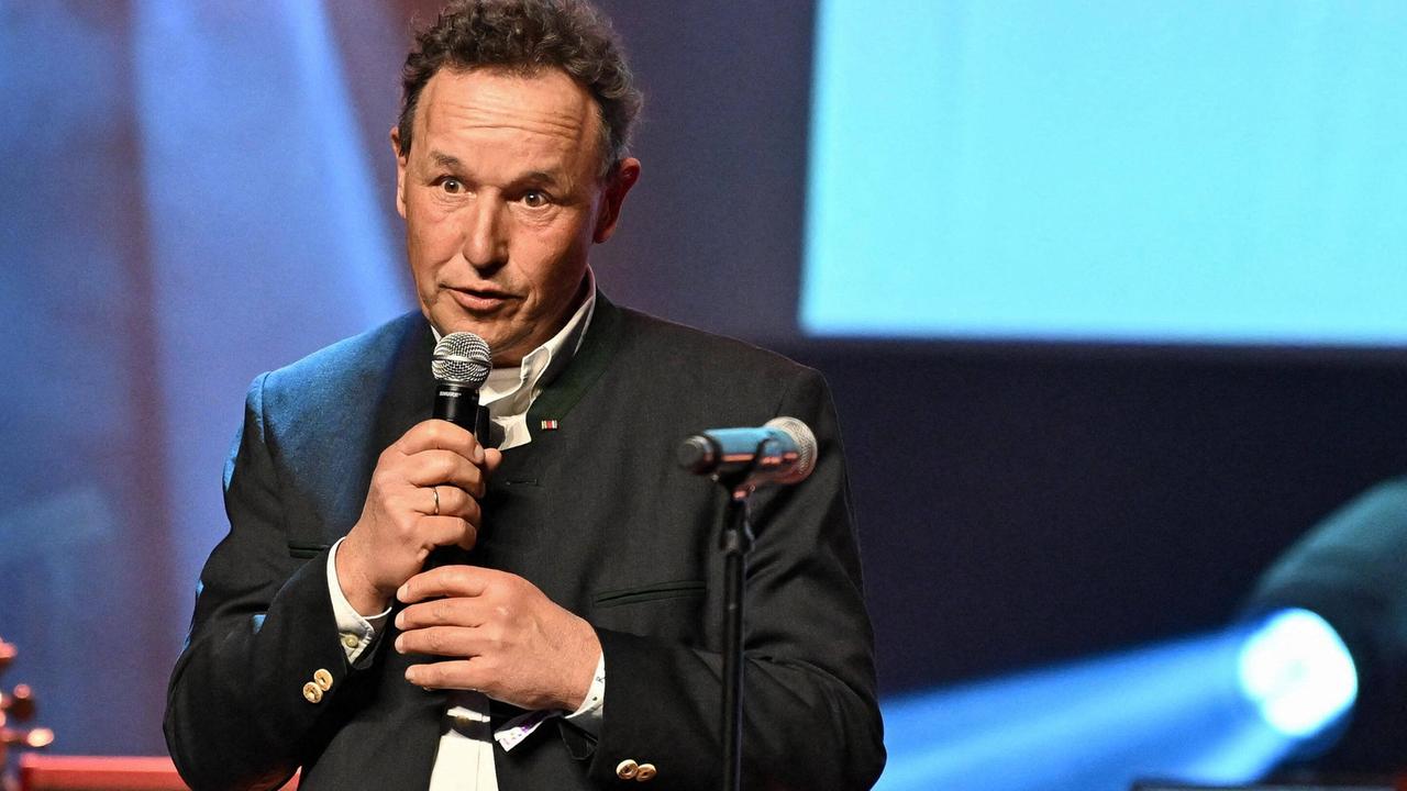 Christian Haass spricht bei einer Gala mit einem Micro in der Hand. 