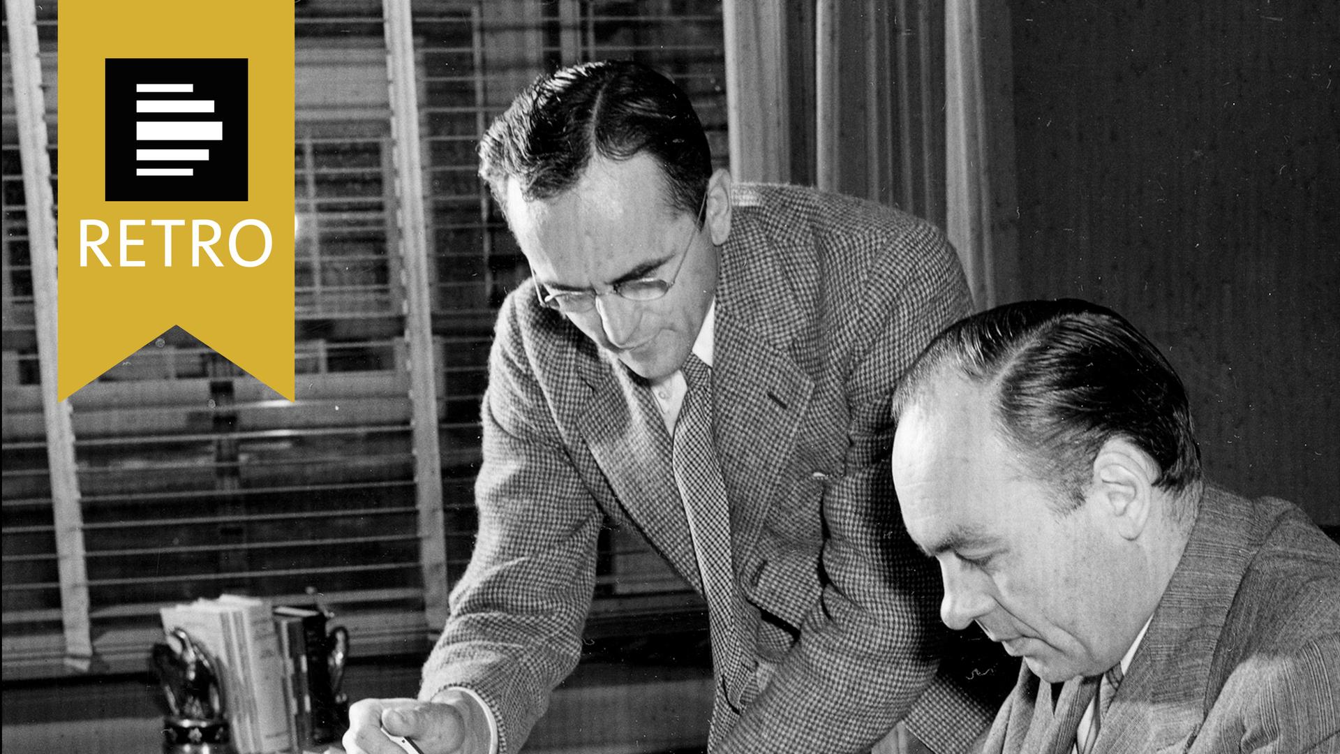 Dr. George Gallup, Direktor des American Institute for Public Opinion, und der leitende Statistiker des Instituts, Edward G. Benson, stehend, arbeiten am 7. August 1941 gemeinsam in einem Büro in Princeton, New Jersey.