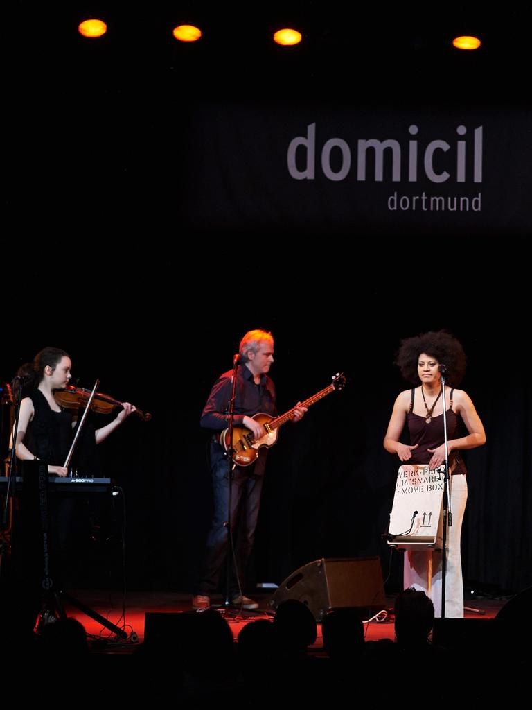 Die aus Kuba stammende Sängerin Addys Mercedes steht bei einem Konzert im Jazzclub Domicil in Dortmund mit ihren Musikern auf der Bühne, während im Hintergrund der Clubname zu lesen ist.