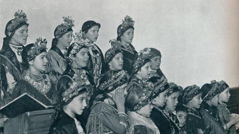 Eine historische Fotografie zeigt ungarische Mädchen, die 1932 in ihren Trachten einen Chor bilden.