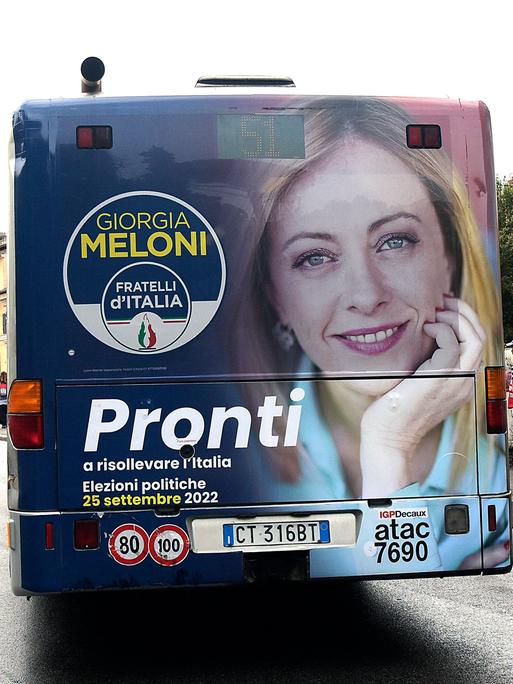 Ein Bus mit dem Konterfei Giorgia Melonis auf der Rückseite fährt über die Straßen Roms.