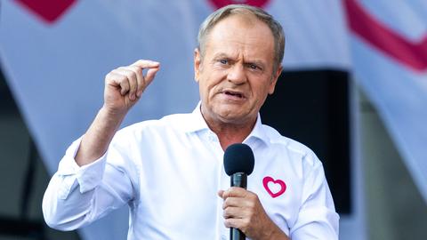 Der polnische Ministerpräsident Tusk mit Mikrofon und weißem Hemd.