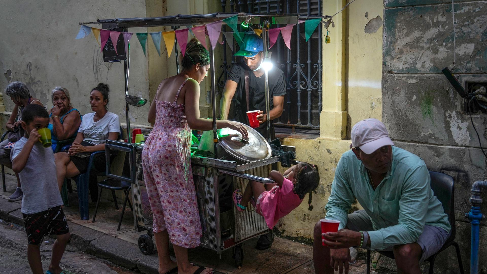 Havanna: Eine Frau kauft Suppe von einem Straßenhändler. 