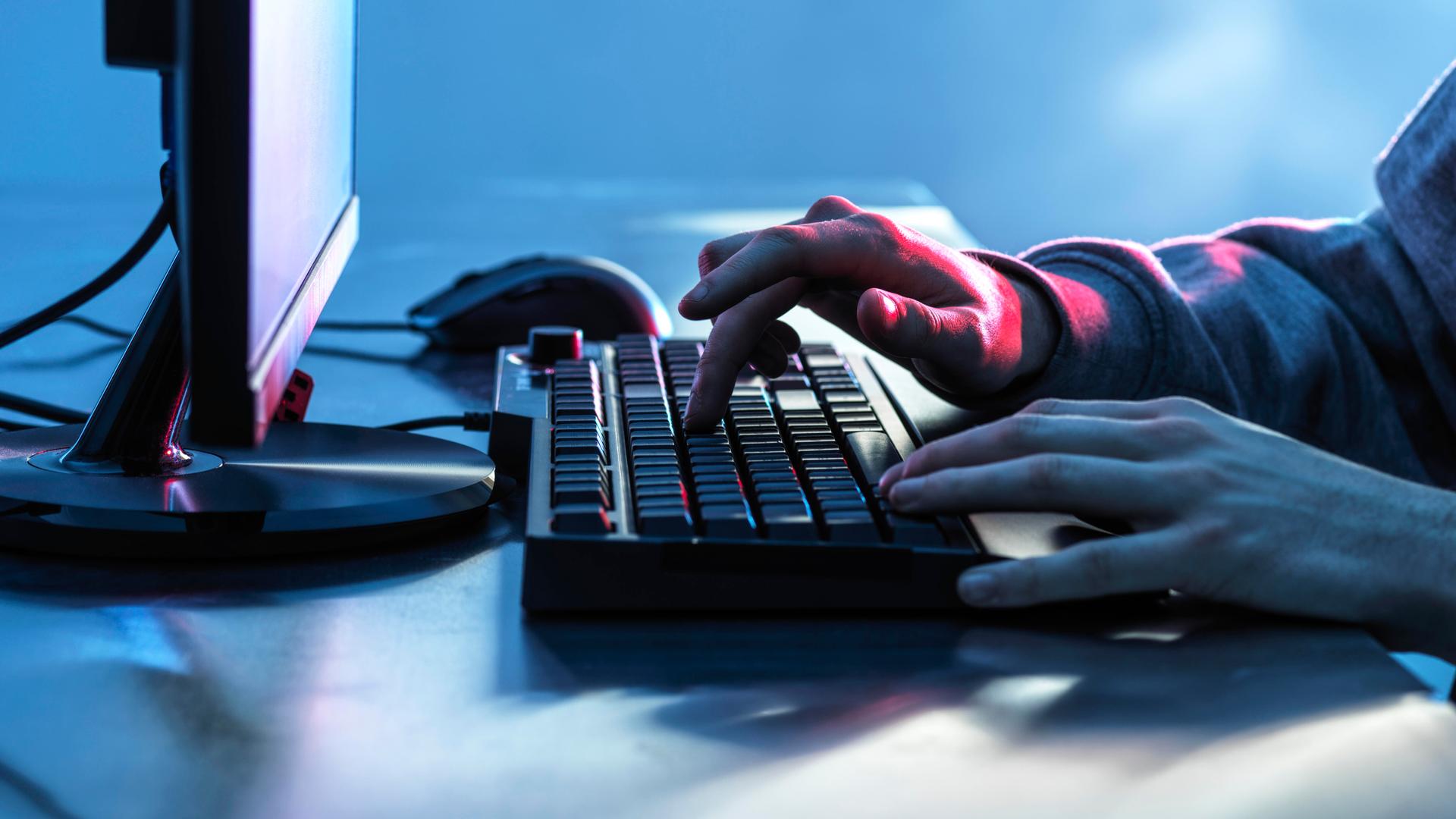 Hände eines Teenagers auf der Tastatur eines Computers 