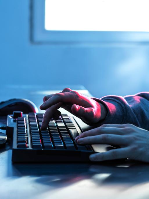 Hände eines Teenagers auf der Tastatur eines Computers 