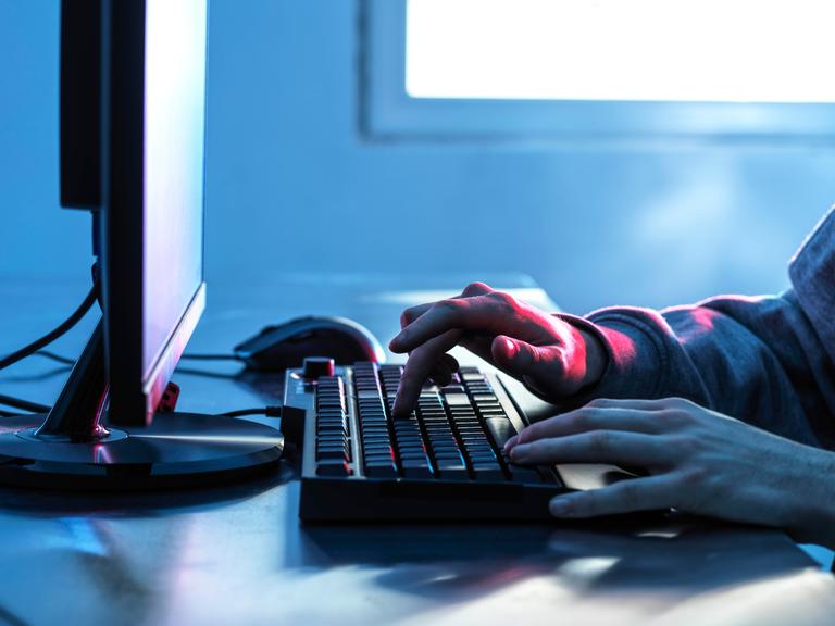 Hände eines Teenagers auf der Tastatur eines Computers 
