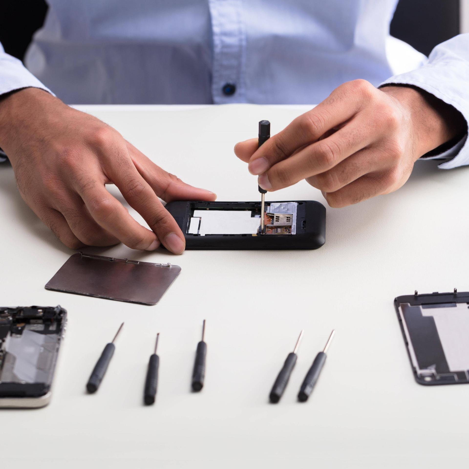 Eine Person repariert ein Handy.