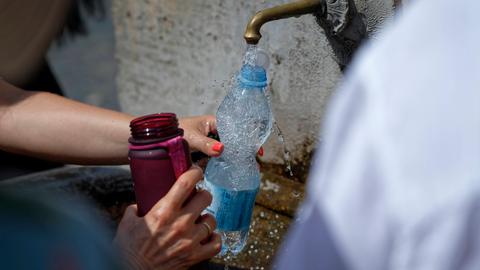 Extreme Hitze beeinträchtigt das tägliche Leben in Italien: Touristen füllen ihre Wasserflaschen an einem öffentlichen Brunnen in Rom im Sommer 2024 auf.