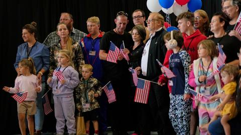 Die erste Gruppe weißer Südafrikaner, denen die US-Regierung Flüchtlingsstatus erteilt hat, trifft mit US-Fähnchen am Dulles International Airport ein. 