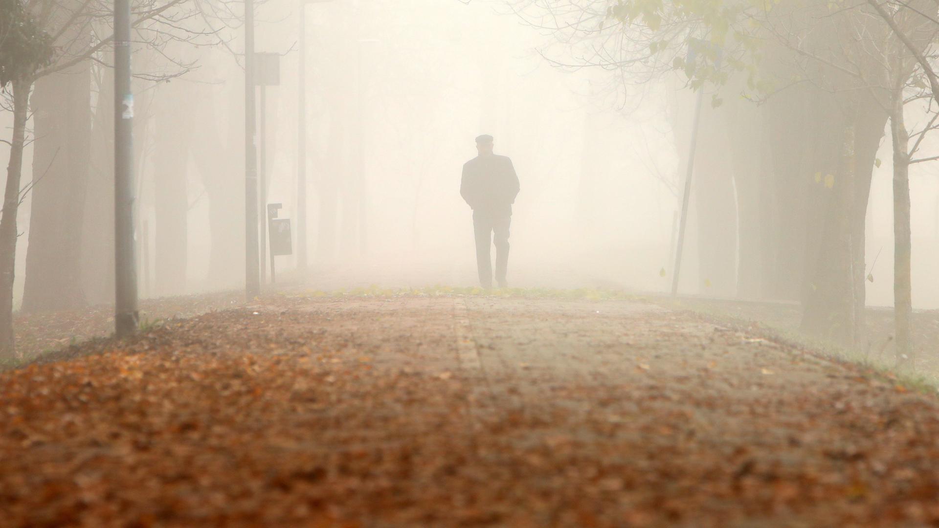 Ein Mann geht im Nebel spazieren. 