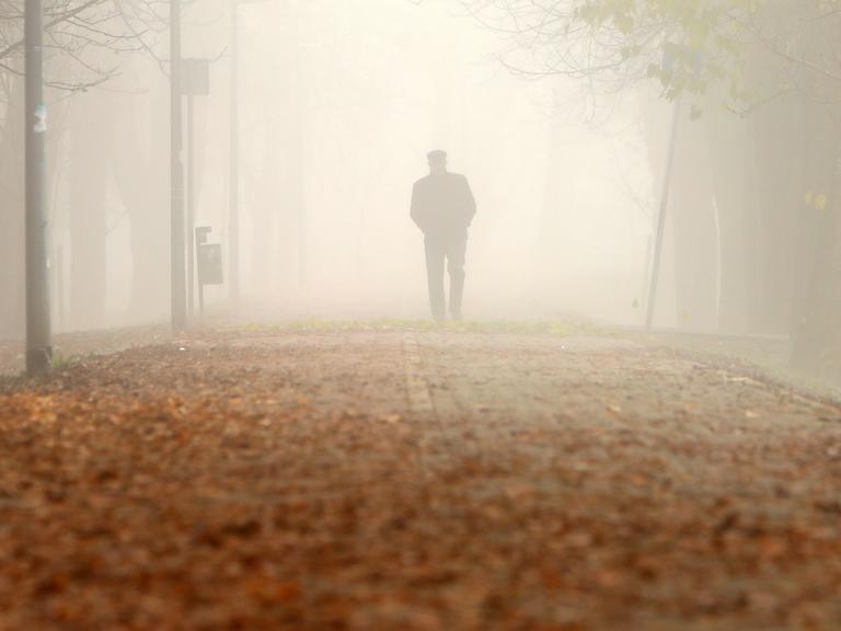 Ein Mann geht im Nebel spazieren. 