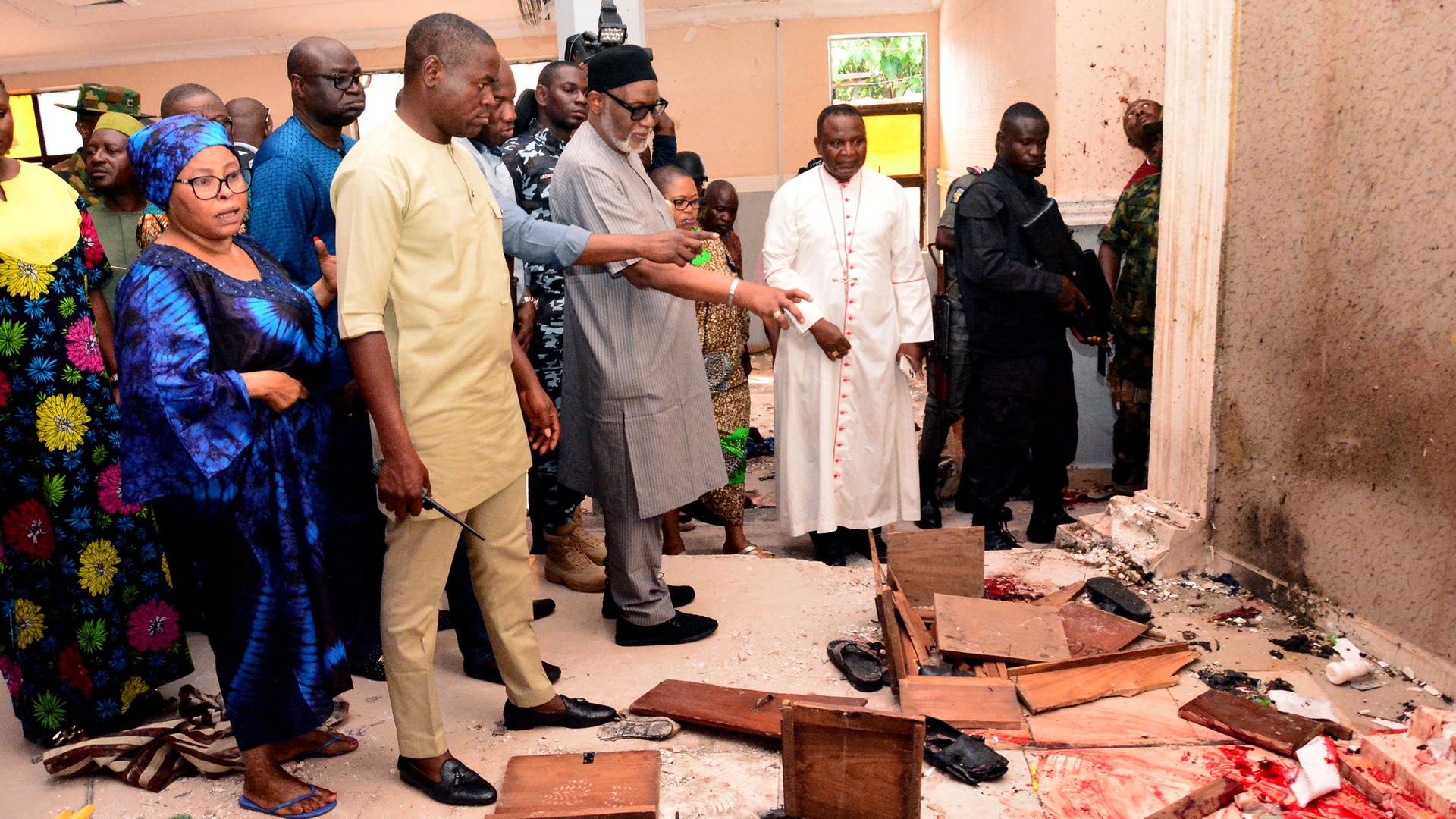 Das Foto zeigt Menschen in der Kirche, wo der Überfall war. Auch der Geouverneur des nigerianischen Bundes-Staates Ondo ist dabei.