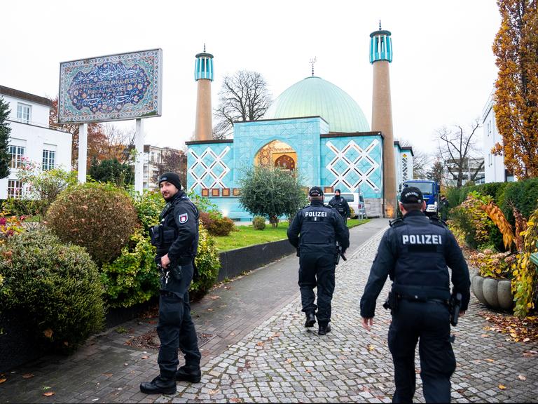 Einsatzkräfte der Polizei stehen während einer Razzia beim islamischen Zentrum Hamburg vor der Imam Ali Moschee (Blaue Moschee) an der Außenalster.
