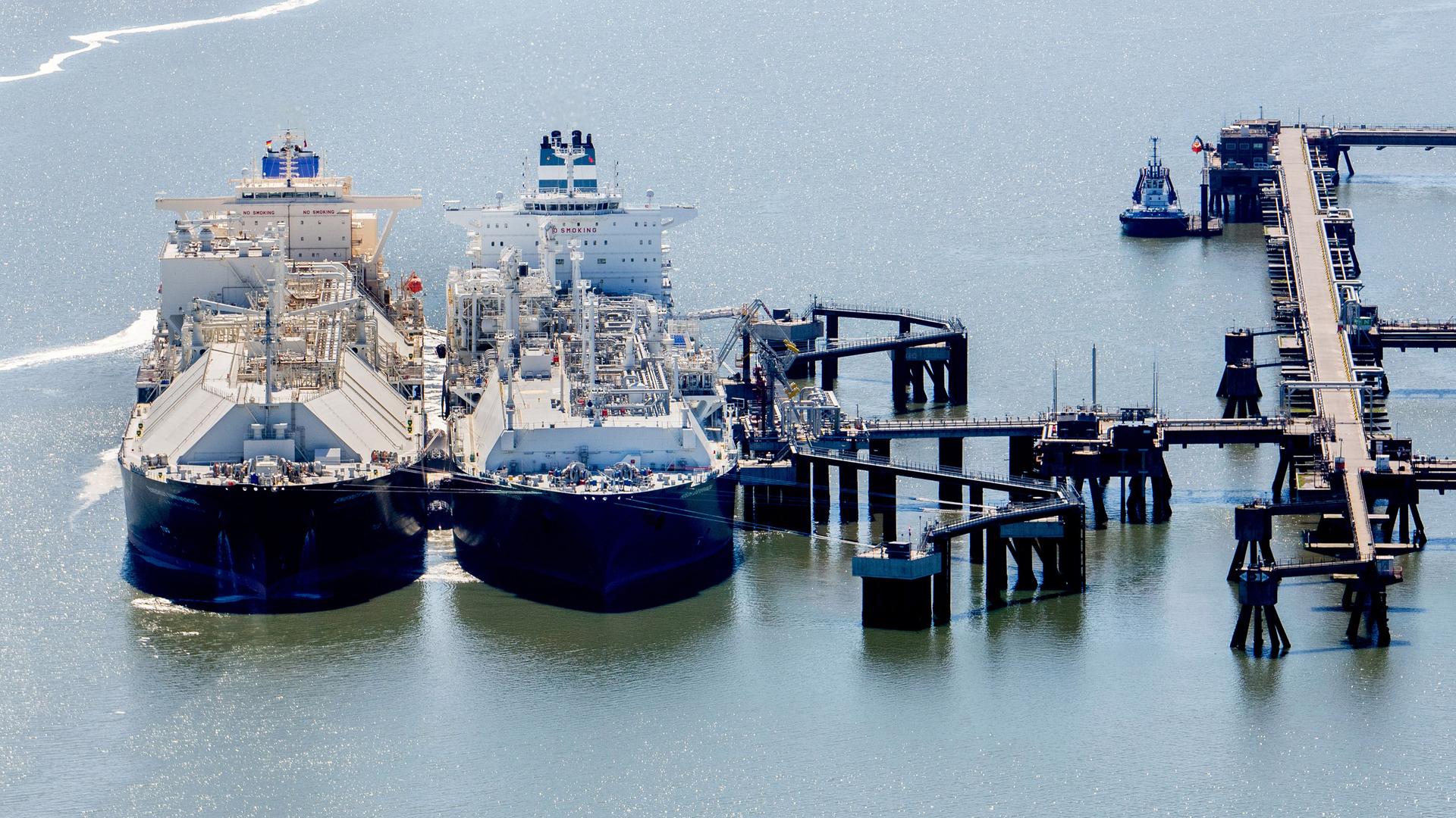 Zwei Schiffe liegen an einem Anleger vor Wilhelmshaven, über den Flüssigerdgas angelandet und regasifiziert wird. 