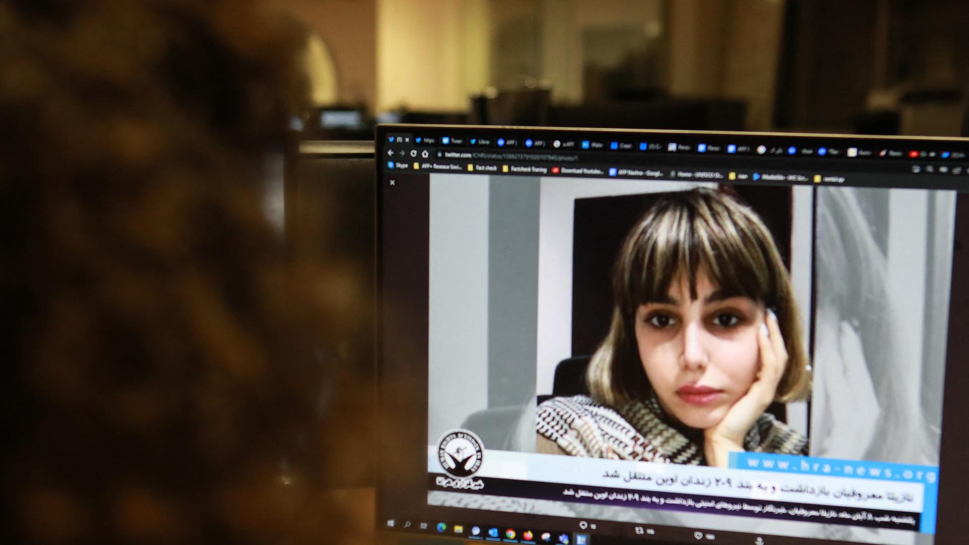 (FILES) A woman in the Cypriot capital Nicosia looks at a screen on November 4, 2022, displaying an undated video of Iranian journalist Nazila Maroufian, who according to a Norway-based human rights organisation, was arrested by the Iranian authorities on October 30, after she interviewed the father of Mahsa Amini. Maroufian said on August 13, 2023 that she had been released from jail, posting a picture of herself on social media after her release from Tehran's Evin prison. (Photo by Alex MITA / AFP)