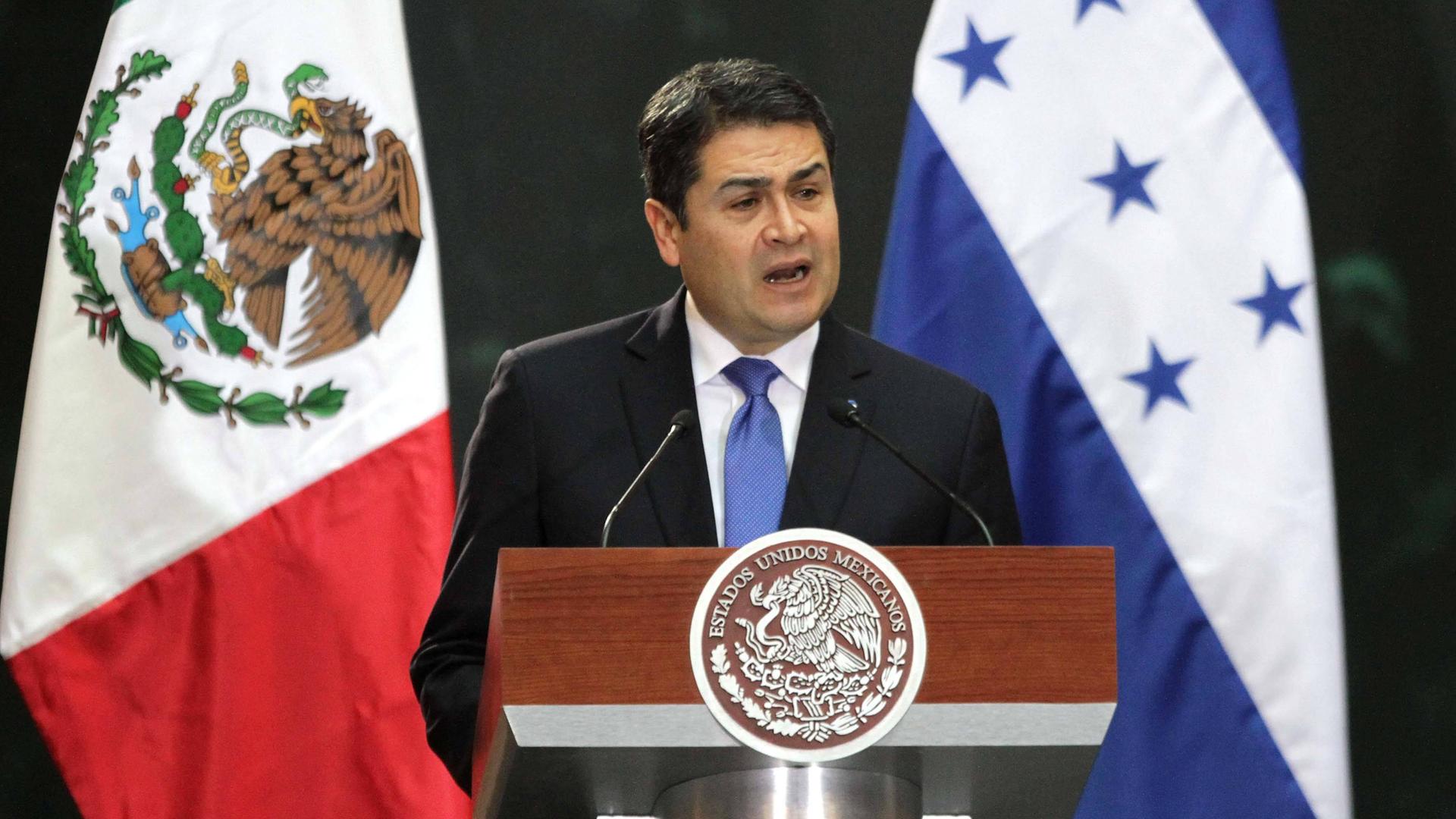 Der ehemalige Staatschef von Honduras, Juan Orlando Hernández, spricht an einem Rednerpult. Der ehemalige Staatschef von Honduras, Juan Orlando Hernández, spricht an einem Rednerpult.
