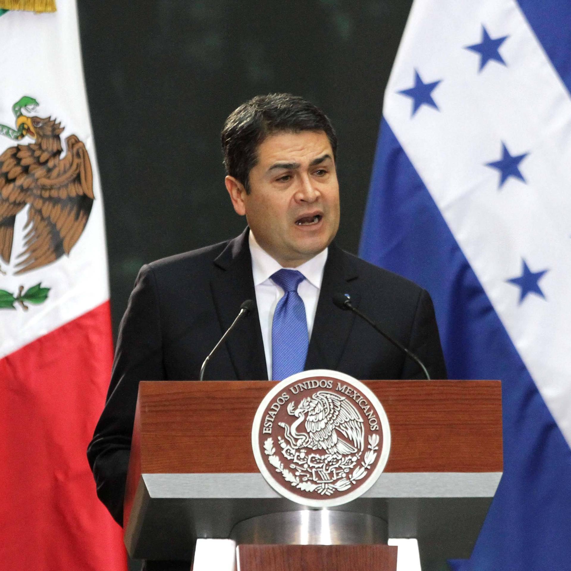 Der ehemalige  Staatschef von Honduras, Juan Orlando Hernández, spricht an einem Rednerpult. 