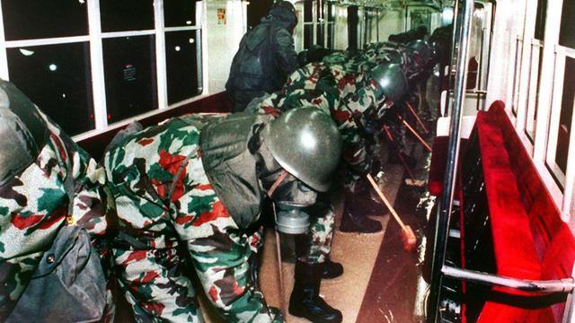 Soldaten in Schutzanzügen reinigen einen U-Bahnwagen.
