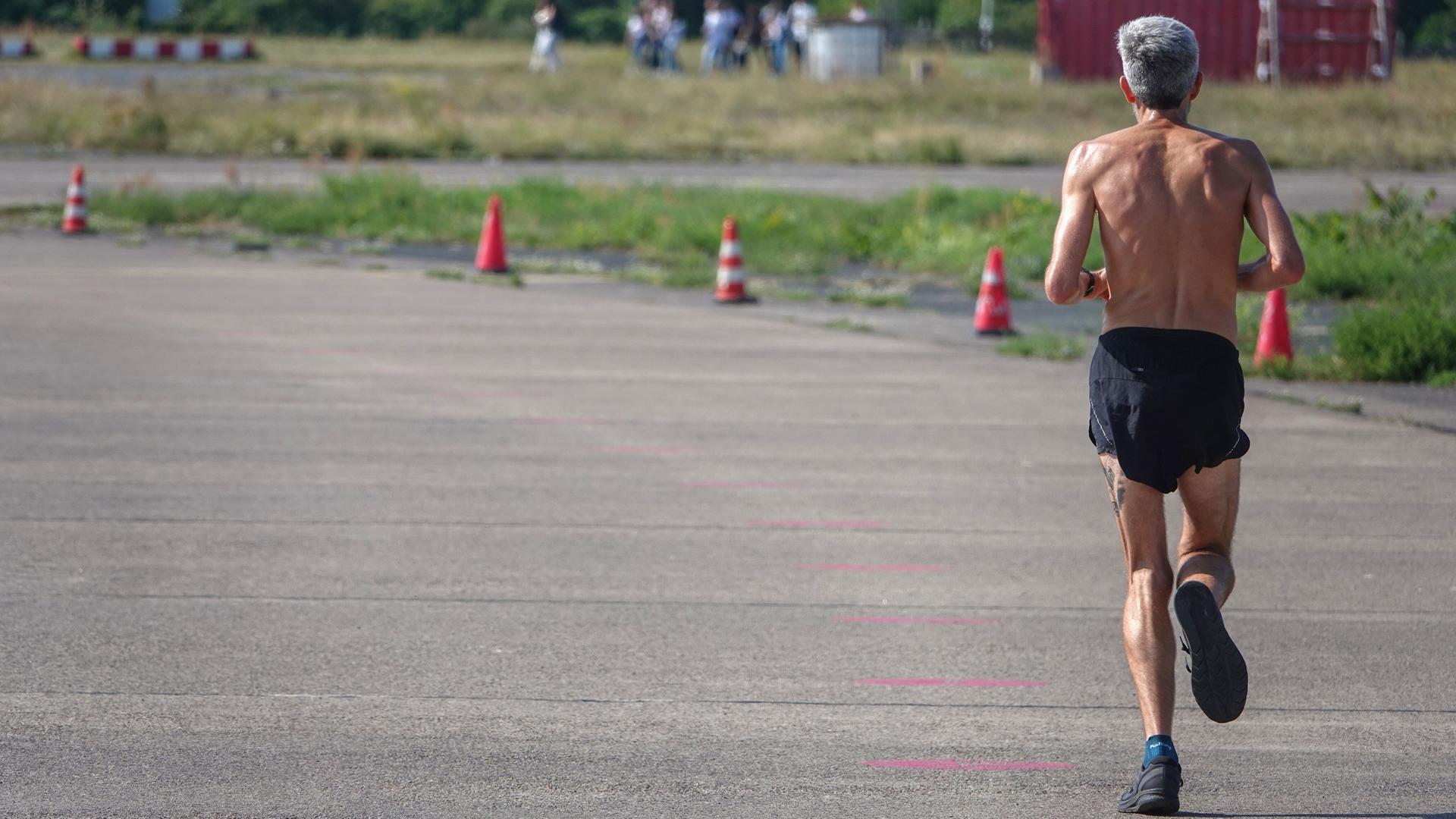 Ein Mann joggt auf einem stillgelegten Rollfeld auf dem Tempelhofer Feld in Berlin.