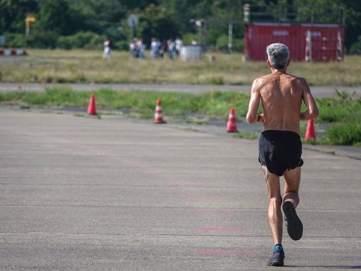 Ein Mann joggt auf einem stillgelegten Rollfeld auf dem Tempelhofer Feld in Berlin.