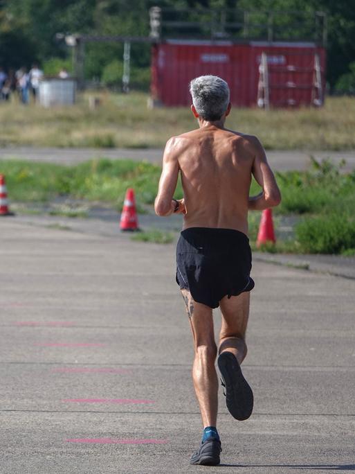 Ein Mann joggt auf einem stillgelegten Rollfeld auf dem Tempelhofer Feld in Berlin.