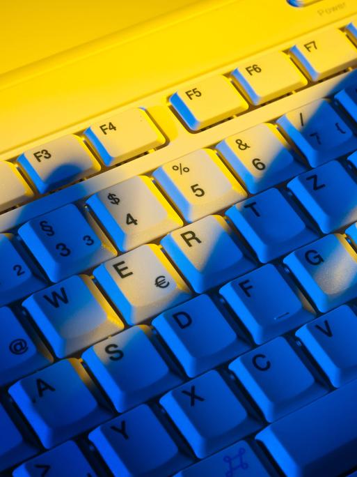 Schatten einer Hand über einer Computertastatur