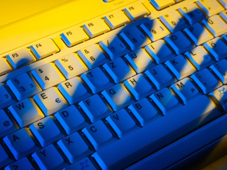 Schatten einer Hand über einer Computertastatur