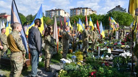 Ukrainische Soldaten huldigen am 35. Unabhängigkeitstag der Ukraine im Rahmen einer Zeremonie zu Ehren der Helden der Ukraine, die im Russisch-Ukrainischen Krieg gefallen sind, auf dem Lytschakiw-Friedhof in Lemberg, Ukraine. 