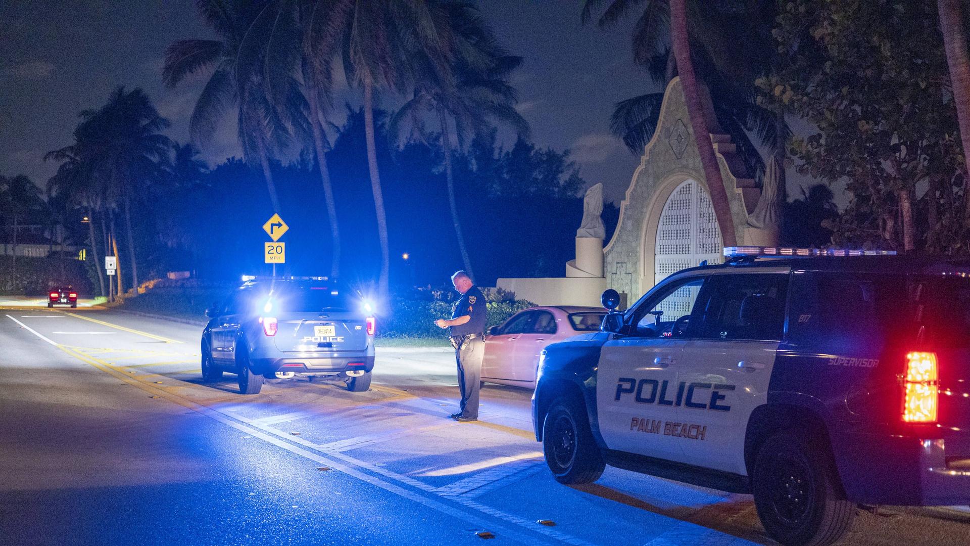 Zwei Polizeiwagen stehen in der Nacht vor dem Anwesen Mar-a-Lago von Donald Trump in Florida.