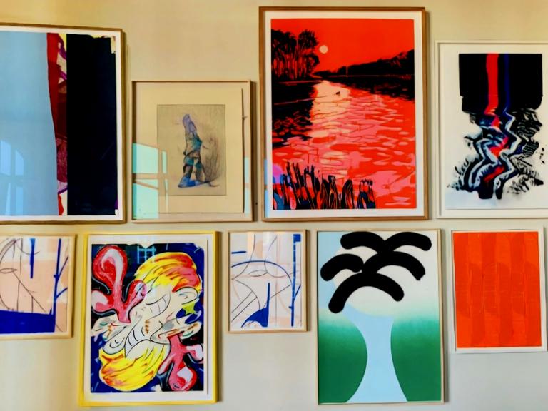 Neun gerahmte Bilder hängen an einer Wand. Das Foto wurde auf der Releaseparty der Handsiebdruckerei Editionen gemacht. Neun gerahmte Bilder hängen an einer Wand. Das Foto wurde auf der Releaseparty der Handsiebdruckerei Editionen gemacht.