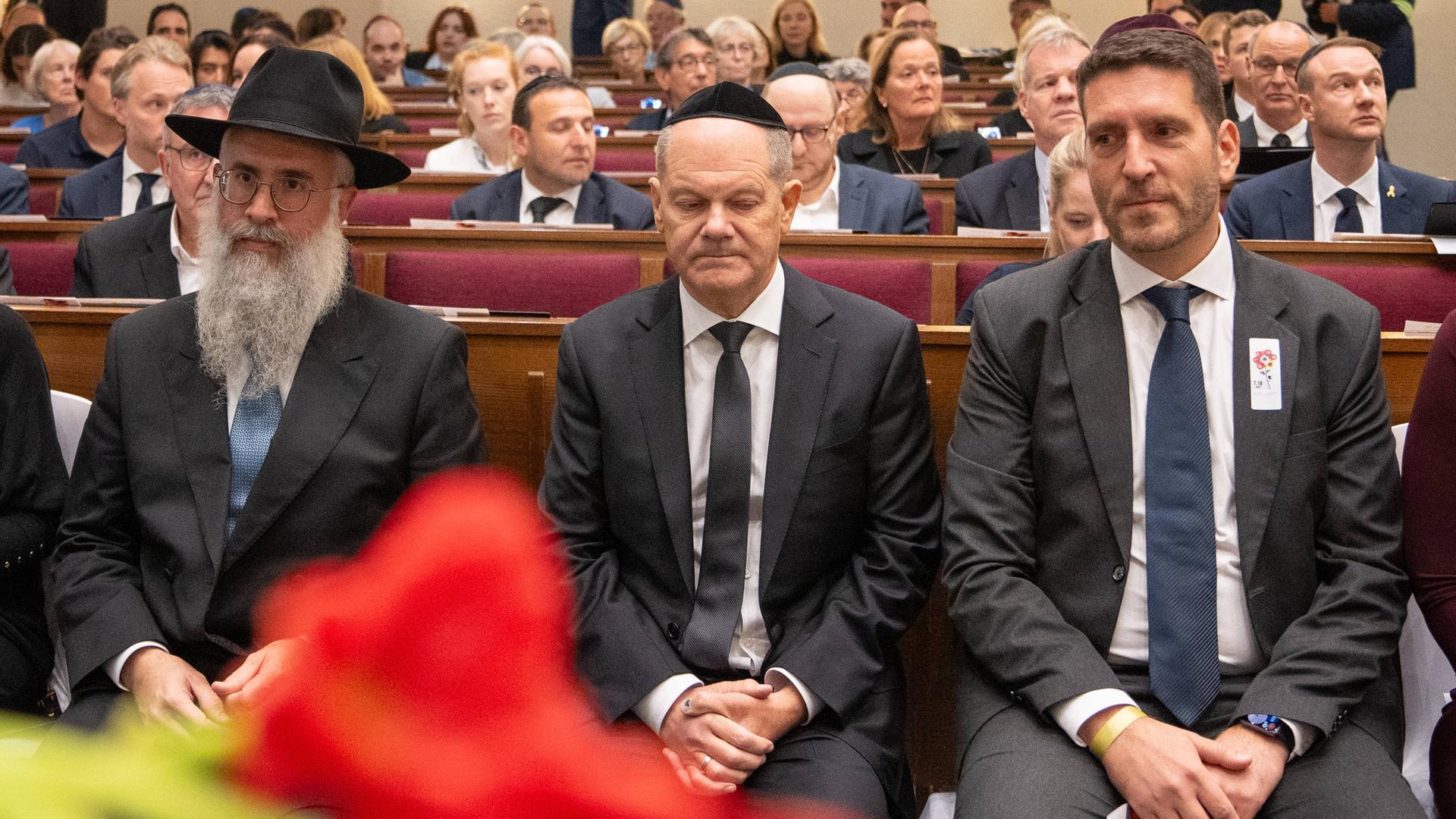 Gedenkzeremonie am ersten Jahrestag des Angriffs der Hamas-Terroristen auf Israel: Bundeskanzler Olaf Scholz mit Kippa in einer Synagoge mit Hamburgs Landesrabbiner Shlomo Bistritzky und Philipp Stricharz, Erster Vorsitzender der Jüdischen Gemeinde.