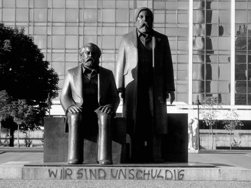 Das Karl Marx und Friedrich Engels-Denkmal vor dem Palast der Republik in Berlin mit dem Graffiti "Wir sind unschuldig", 1990.