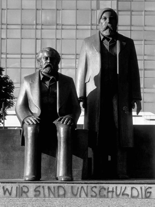 Das Karl Marx und Friedrich Engels-Denkmal vor dem Palast der Republik in Berlin mit dem Graffiti "Wir sind unschuldig", 1990.
