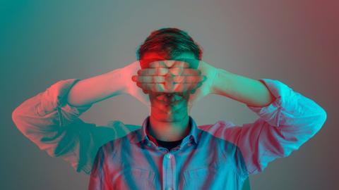 Digital übreinandergelegtes Bild eines Mannes, der seine Arme herunterhänen lässt und sich gleichzeitig die Hände vor die Augen hält. 