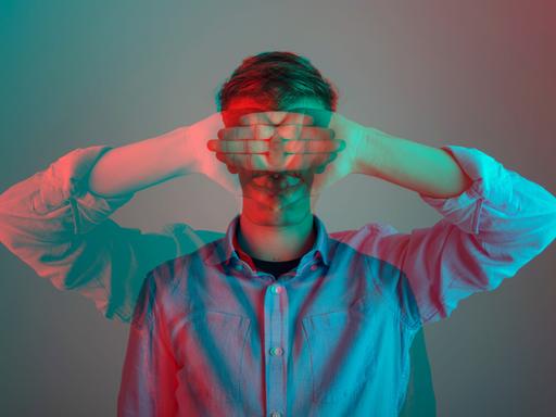 Digital übereinandergelegtes Bild eines Mannes, der seine Arme herunterhängen lässt und sich gleichzeitig die Hände vor die Augen hält.