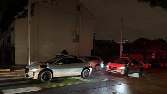 Ein selbstfahrendes Auto bleibt im Dunkeln an einer Ampel stehen.