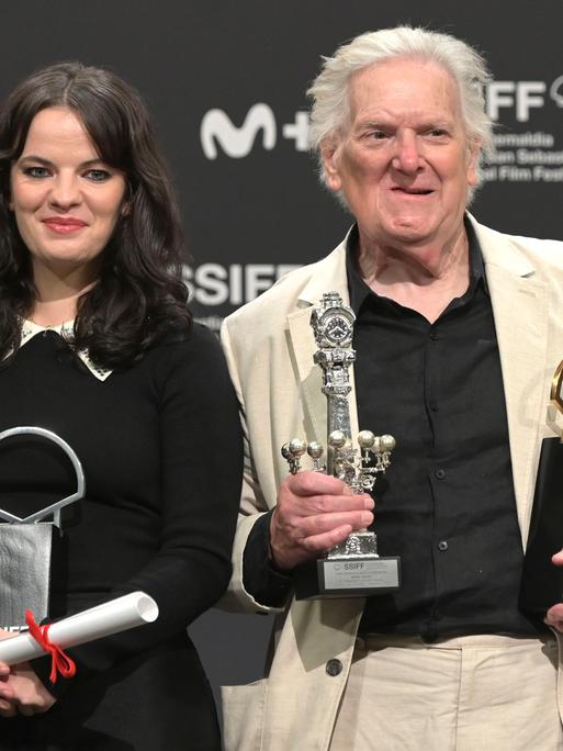 Die Schauspielerin Alice Bailey Johnson und der Schauspieler Paul Jesson halten beim Filmfefst in San Sebastian mehrere Preise in ihren Händen. Hinter ihnen eine Wand mit den Logos der Sponsoren. Die Schauspielerin Alice Bailey Johnson und der Schauspieler Paul Jesson halten beim Filmfefst in San Sebastian mehrere Preise in ihren Händen. Hinter ihnen eine Wand mit den Logos der Sponsoren.