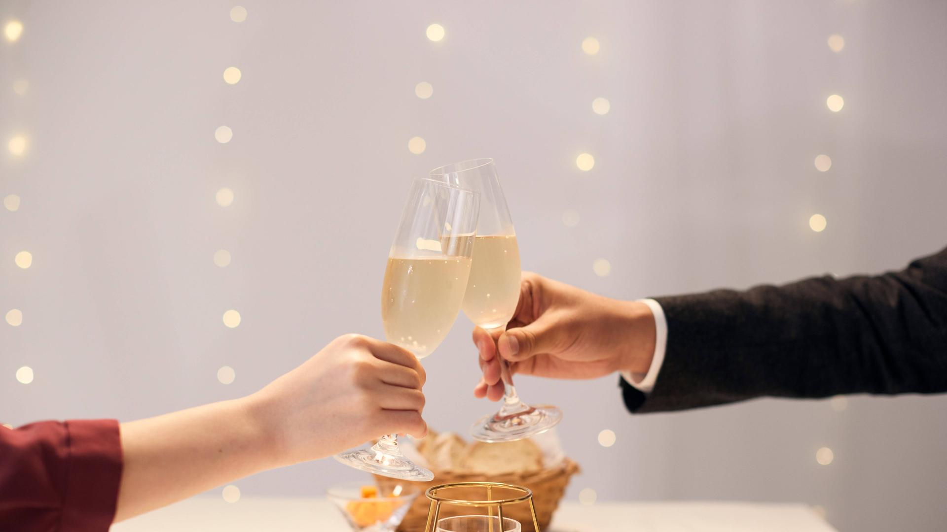 Mann und Frau stoßen mit Champagner an.